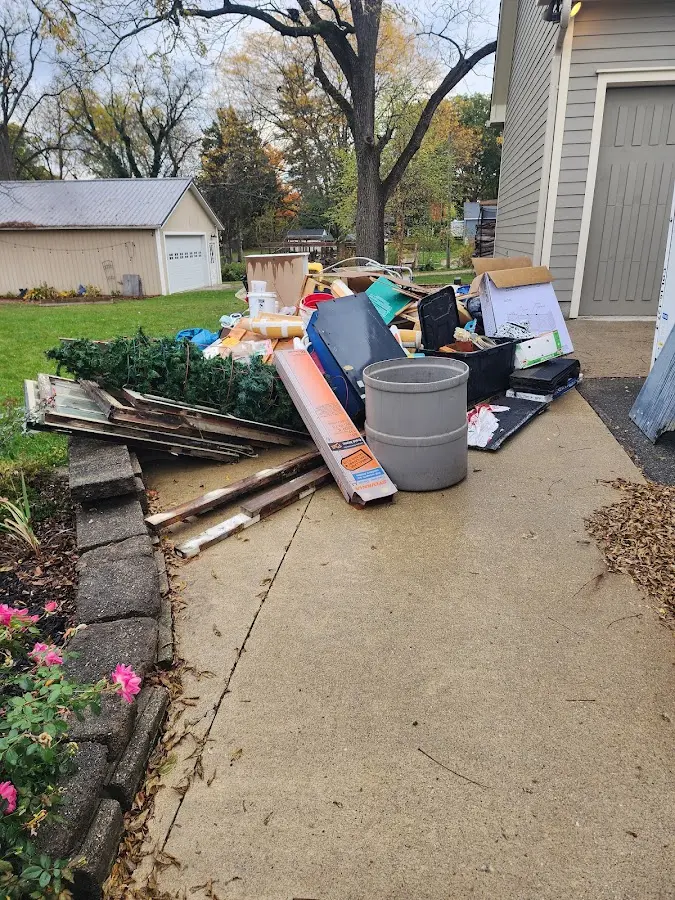 Dumpster being loaded with debris for Estate Cleanout Dumpster Rental in Mason City